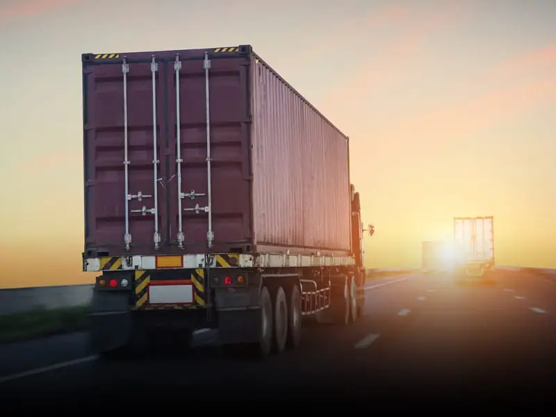 Truck transporting a shipping container on a logistics route